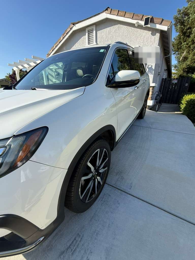 2019 Honda Pilot Touring AWD in White Diamond Pearl, parked in driveway